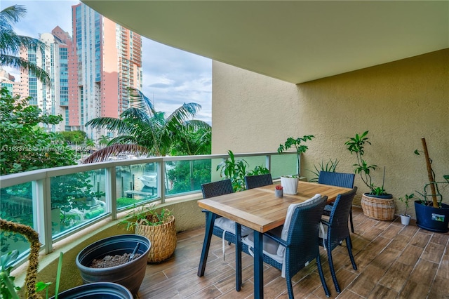 balcony with outdoor dining area and a city view