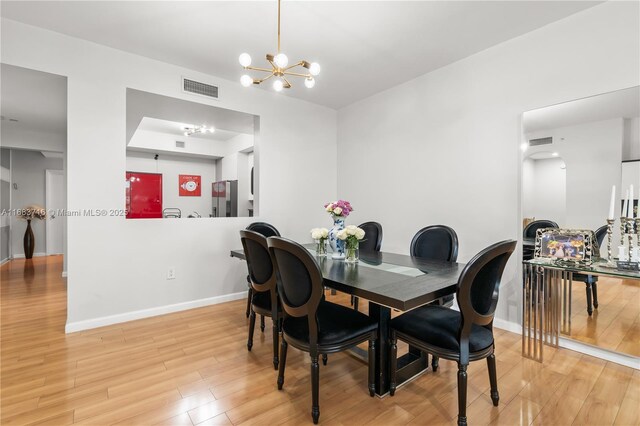 dining room featuring light hardwood / wood-style floors and a notable chandelier