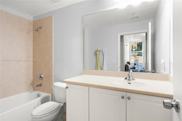 full bathroom featuring tiled shower / bath combo, vanity, and toilet