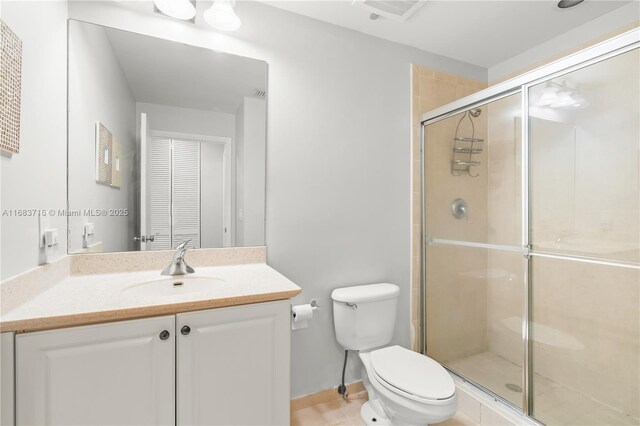 bathroom with vanity, a shower with shower door, and toilet