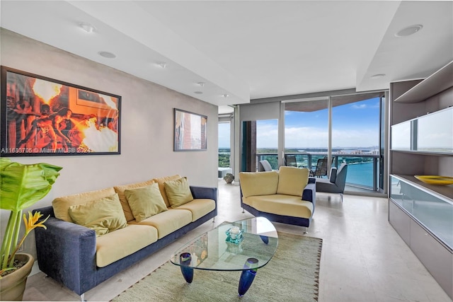 living room featuring a wall of windows and a water view