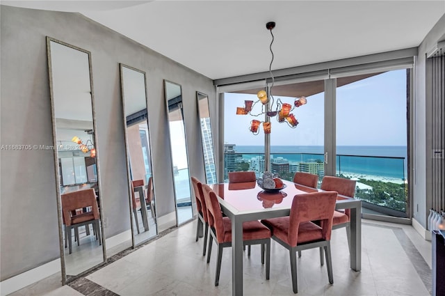 dining room featuring an inviting chandelier, a healthy amount of sunlight, and a water view