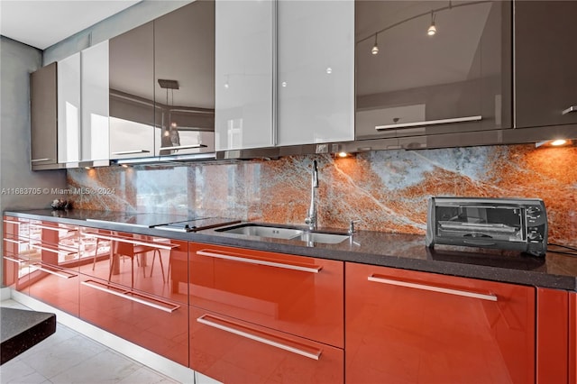 kitchen with backsplash, dark stone counters, light tile patterned flooring, black electric stovetop, and sink