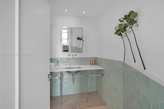 bathroom featuring tile patterned floors, tile walls, and sink