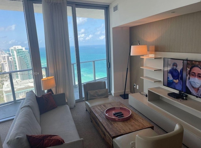 living room with a water view and carpet