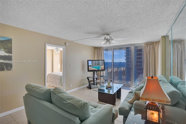 living room featuring ceiling fan, a textured ceiling, and light tile patterned floors