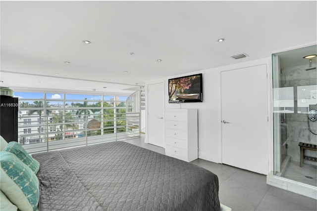 bedroom featuring connected bathroom and expansive windows