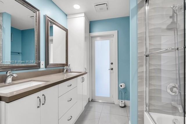 bathroom with vanity, enclosed tub / shower combo, and tile patterned flooring