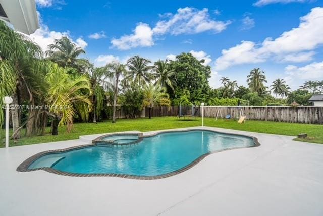 view of swimming pool featuring a yard, a patio area, and an in ground hot tub