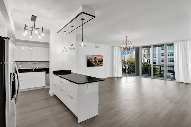 kitchen with a center island, white cabinetry, stainless steel refrigerator with ice dispenser, and tasteful backsplash