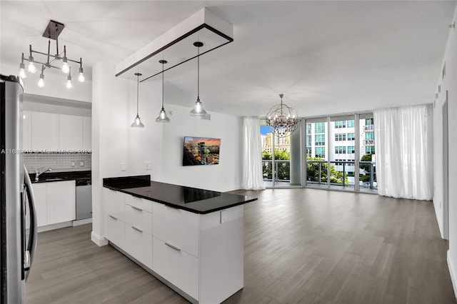 kitchen with white cabinetry, stainless steel appliances, decorative backsplash, and decorative light fixtures