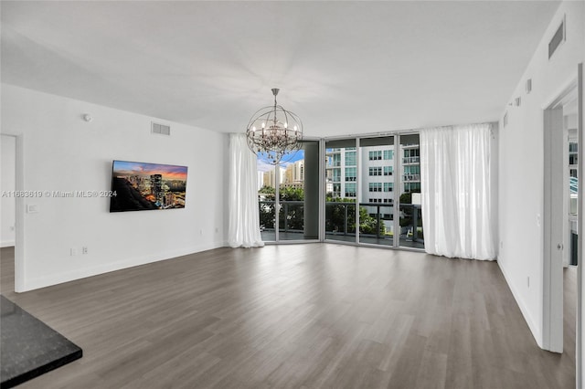 unfurnished living room featuring dark hardwood / wood-style flooring and an inviting chandelier