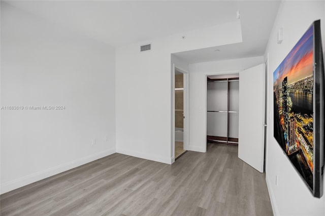 unfurnished bedroom featuring a closet and light hardwood / wood-style flooring