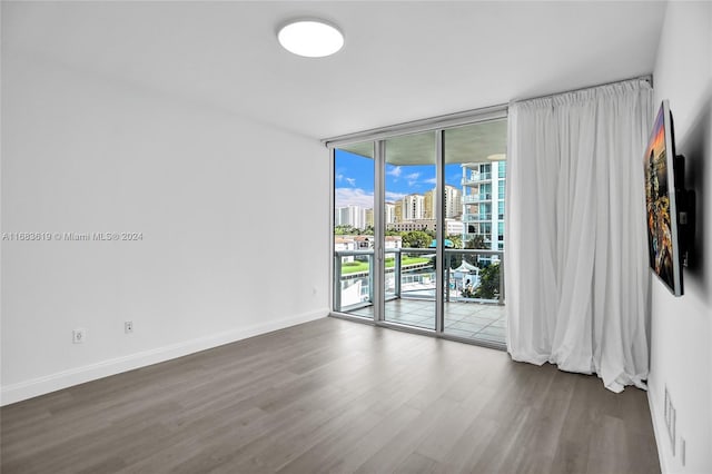 unfurnished room featuring dark hardwood / wood-style floors and floor to ceiling windows