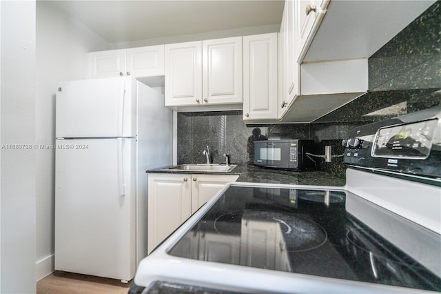 kitchen featuring backsplash, white cabinets, sink, range with electric cooktop, and white fridge