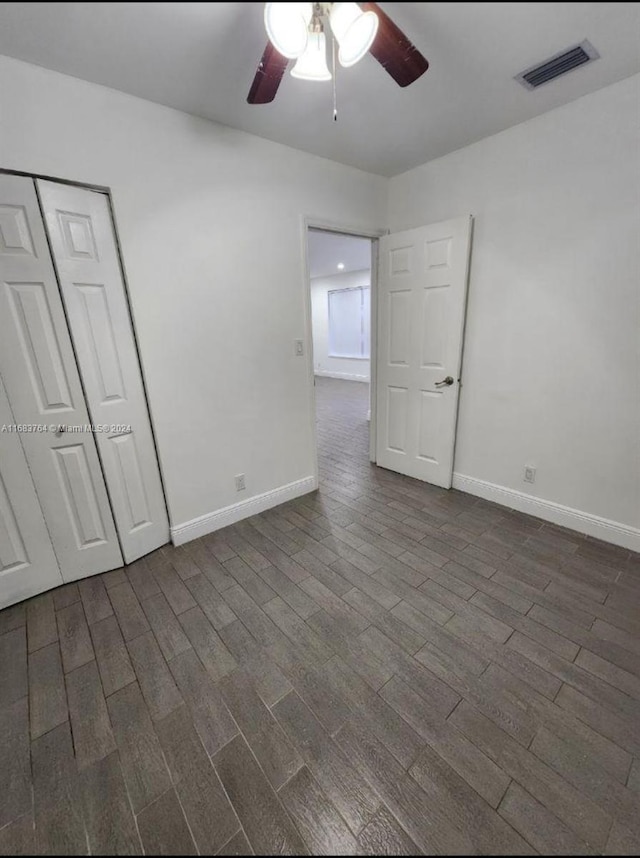 unfurnished bedroom featuring dark hardwood / wood-style floors, a closet, and ceiling fan