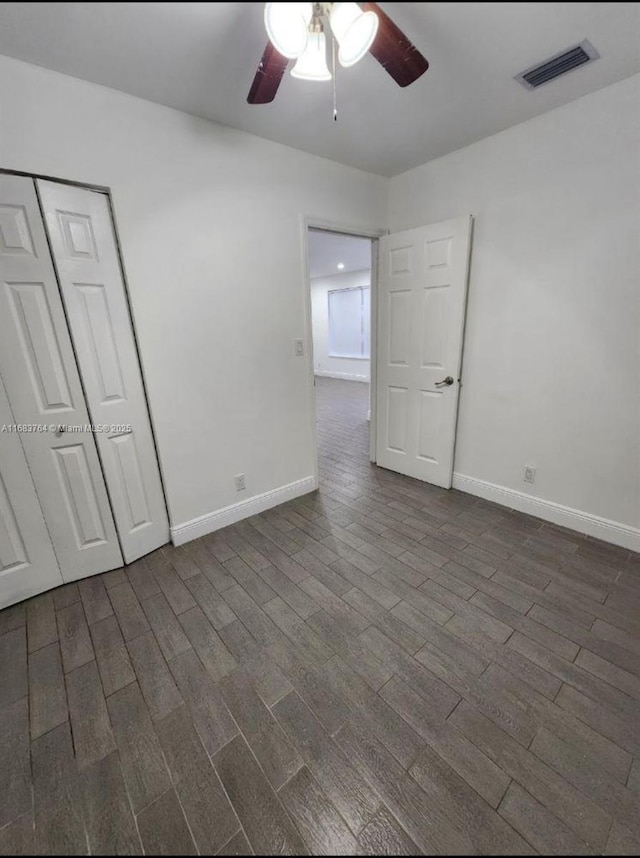 interior space featuring visible vents, baseboards, ceiling fan, and dark wood finished floors