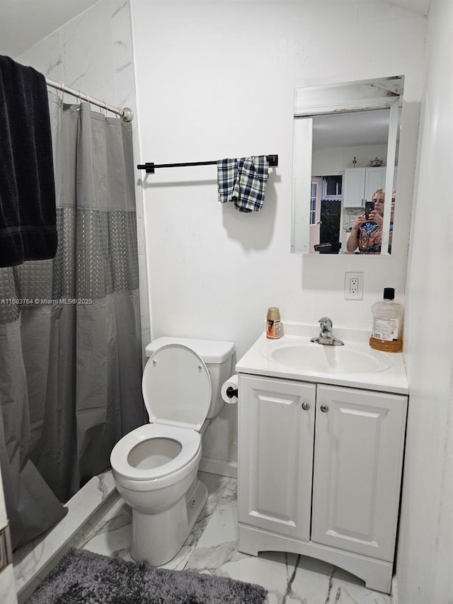 bathroom featuring curtained shower, vanity, marble finish floor, and toilet
