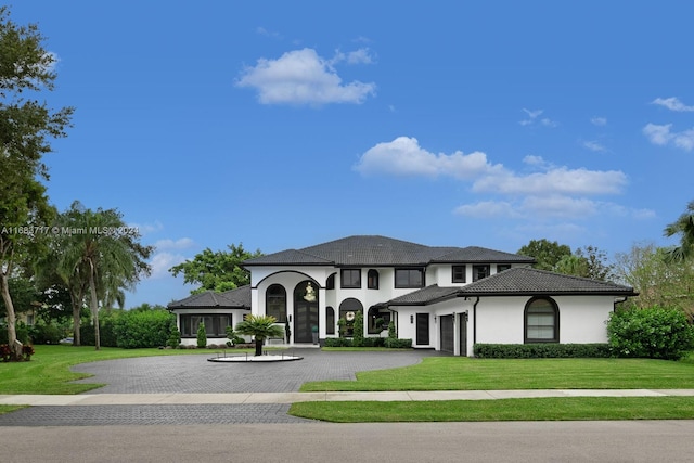 2440 SW 105th Ter, Davie, FL 33324 - view of front of property featuring curved driveway, a front yard, stucco siding, and a garage