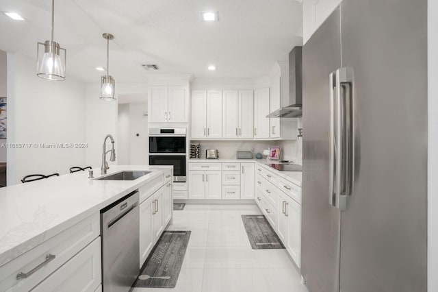 2440 SW 105th Ter, Davie, FL 33324 - kitchen featuring stainless steel appliances, wall chimney exhaust hood, light countertops, hanging light fixtures, and white cabinetry