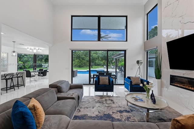 2440 SW 105th Ter, Davie, FL 33324 - living area featuring a premium fireplace, crown molding, a chandelier, and a towering ceiling
