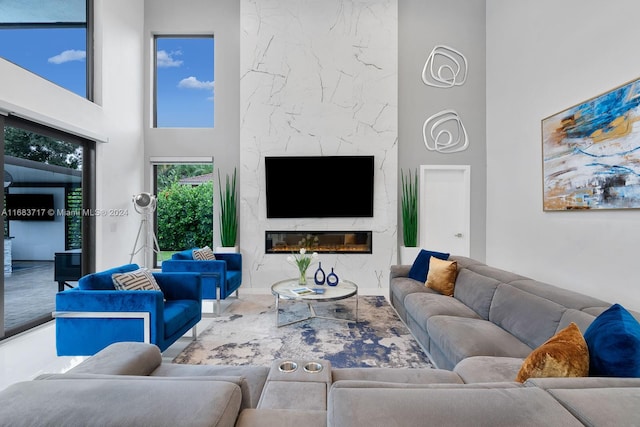 living room with a fireplace and a towering ceiling