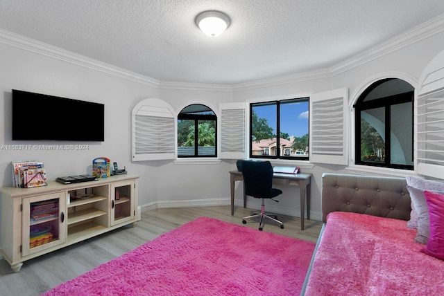 office space with ornamental molding, a textured ceiling, and light wood-type flooring