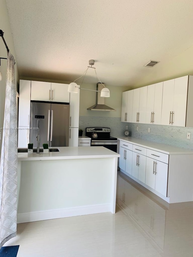 kitchen featuring backsplash, wall chimney exhaust hood, decorative light fixtures, white cabinetry, and stainless steel appliances