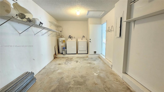 washroom featuring a textured ceiling, laundry area, water heater, washer and clothes dryer, and attic access