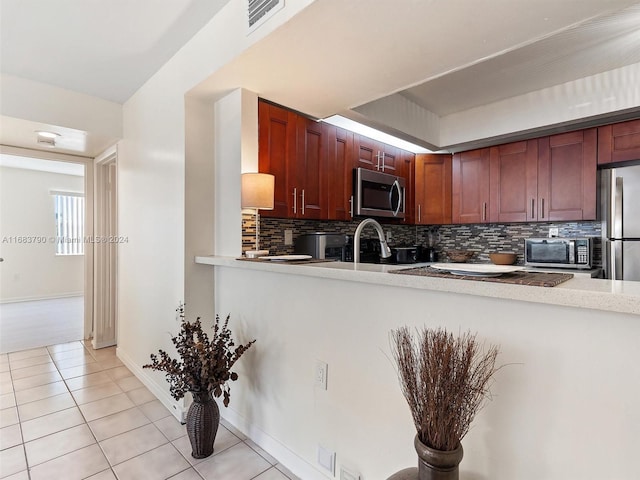 kitchen featuring decorative backsplash, light tile patterned floors, and appliances with stainless steel finishes