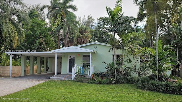 view of front of property featuring covered porch, a front lawn, and a carport