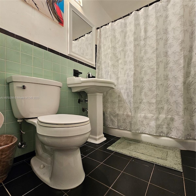 bathroom with toilet, a shower with curtain, tile walls, and tile patterned flooring