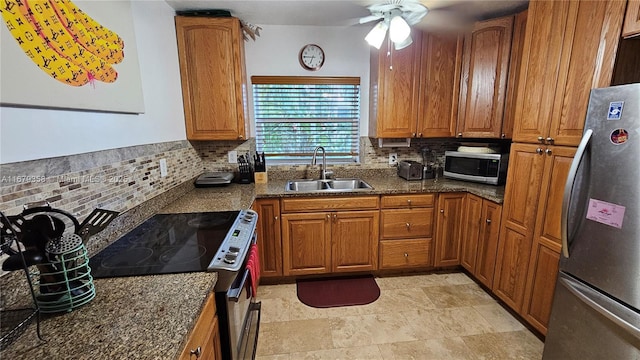 kitchen featuring appliances with stainless steel finishes, ceiling fan, sink, and backsplash