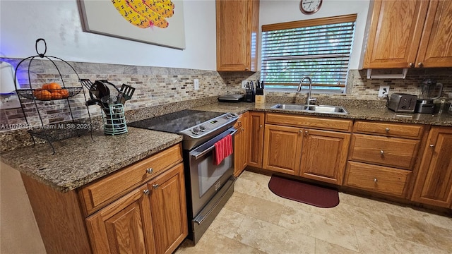 kitchen with electric range, dark stone countertops, sink, and backsplash