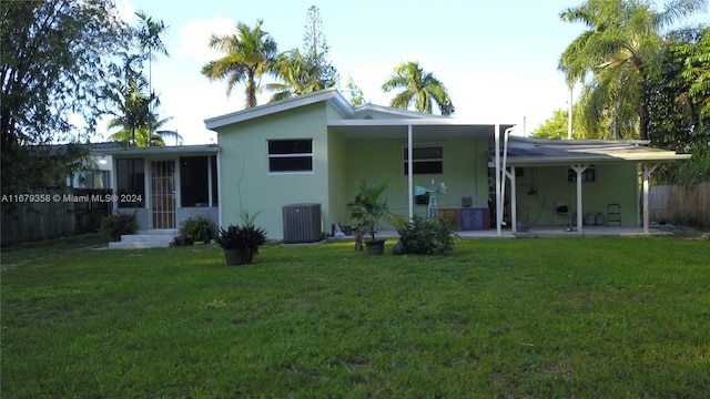 rear view of property featuring a yard, a patio area, and cooling unit