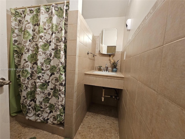 bathroom with tile walls, sink, backsplash, and a shower with shower curtain