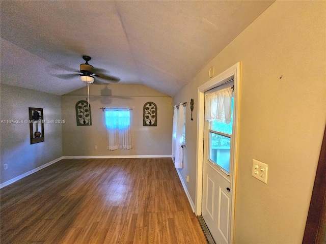 foyer featuring ceiling fan, a wealth of natural light, wood-type flooring, and vaulted ceiling