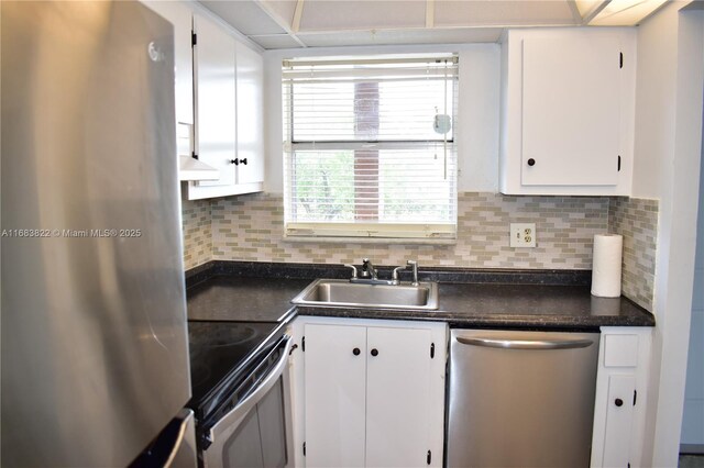 kitchen with sink, backsplash, appliances with stainless steel finishes, and white cabinets