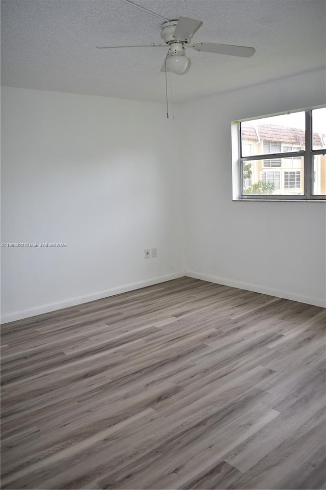 spare room with hardwood / wood-style floors, ceiling fan, and a textured ceiling