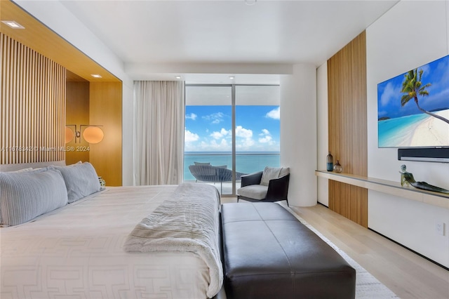 bedroom with access to outside, hardwood / wood-style flooring, and floor to ceiling windows