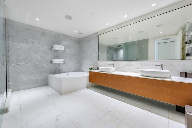 bathroom with vanity, tile walls, and separate shower and tub