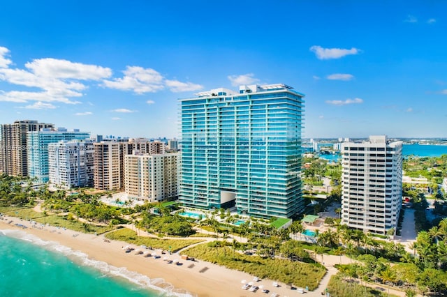 view of building exterior featuring a water view and a beach view