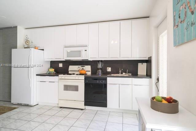 kitchen featuring sink, white cabinetry, decorative backsplash, and white appliances