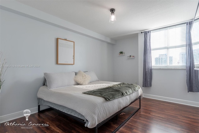 bedroom with dark hardwood / wood-style flooring