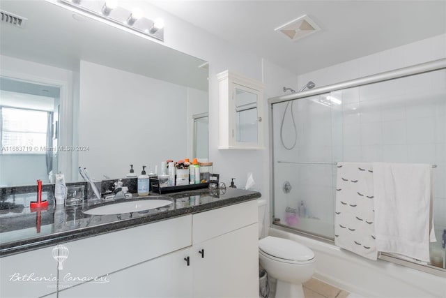 full bathroom with vanity, toilet, combined bath / shower with glass door, and tile patterned flooring