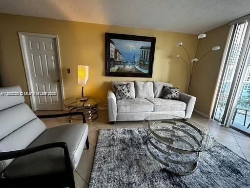 tiled living room featuring a healthy amount of sunlight and a textured ceiling