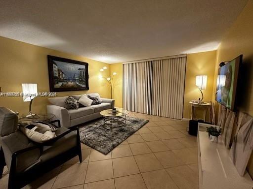 living room featuring a textured ceiling and light tile patterned floors