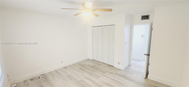 unfurnished bedroom with light hardwood / wood-style flooring, a closet, and ceiling fan