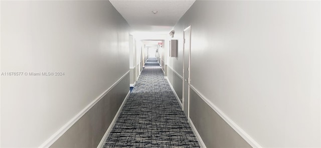 hallway with dark colored carpet