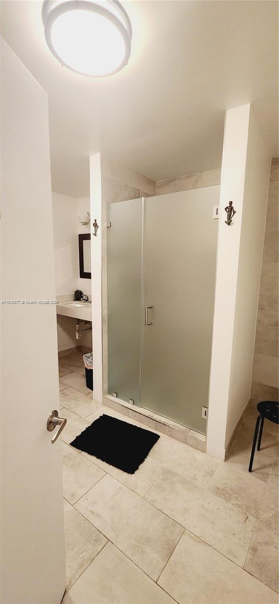 bathroom featuring an enclosed shower and tile patterned flooring